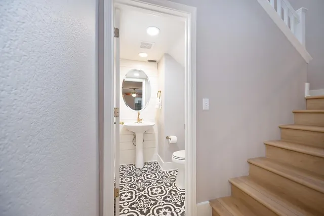 a bathroom with a toilet a sink and mirror
