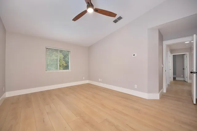 an empty room with closet and a ceiling fan