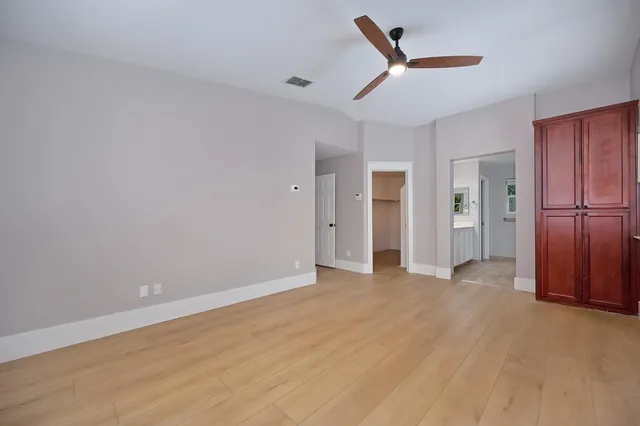 a view of a livingroom with a chandelier fan and wooden floor