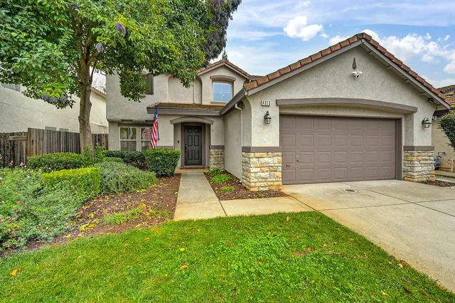 a front view of a house with a yard and garage