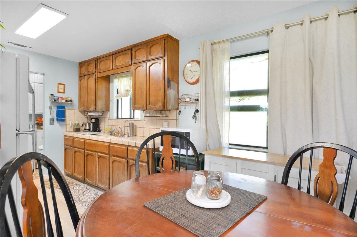 26982 Twin Ponds Road Clovis, CA 93619 - Photo 13 of 48 a kitchen with stainless steel appliances granite countertop a stove a sink a dining table and chairs