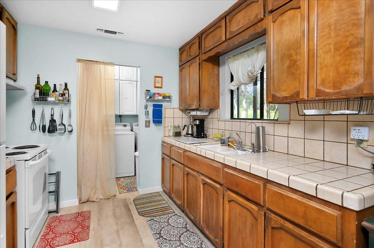 26982 Twin Ponds Road Clovis, CA 93619 - Photo 14 of 48 a bathroom with a sink a mirror and a shower