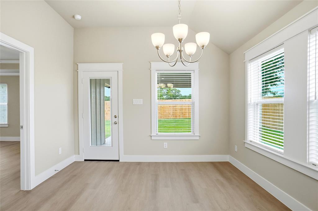 133 Joel Street Springtown, TX 76082 - Photo 6 of 15 an empty room with wooden floor and windows