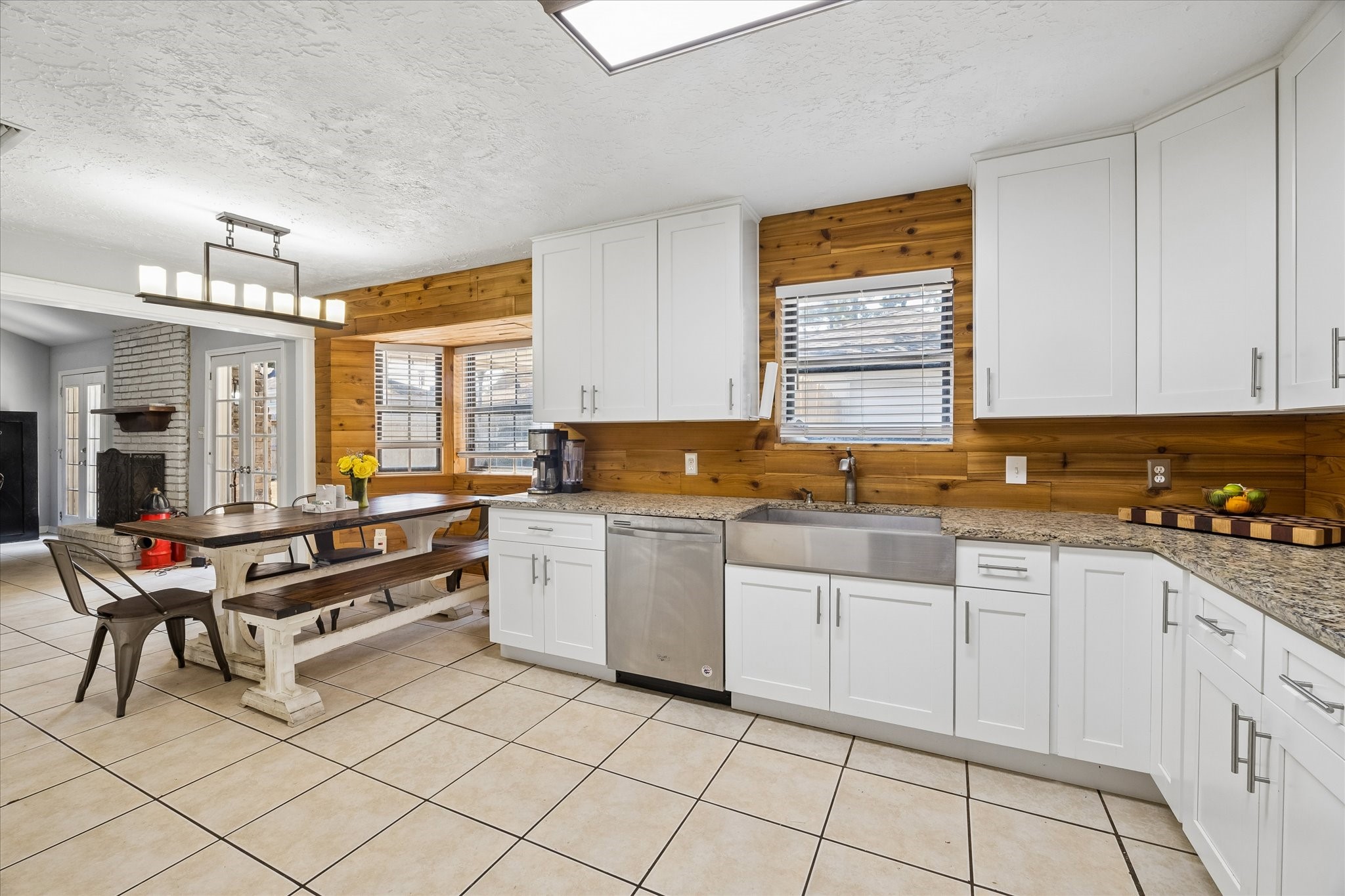 23115 Stepinwolf Lane Spring, TX 77373 - Photo 11 of 18 Charming kitchen with modern white cabinetry, granite countertops, and a farmhouse sink. Features a cozy dining nook with a rustic wood accent wall.