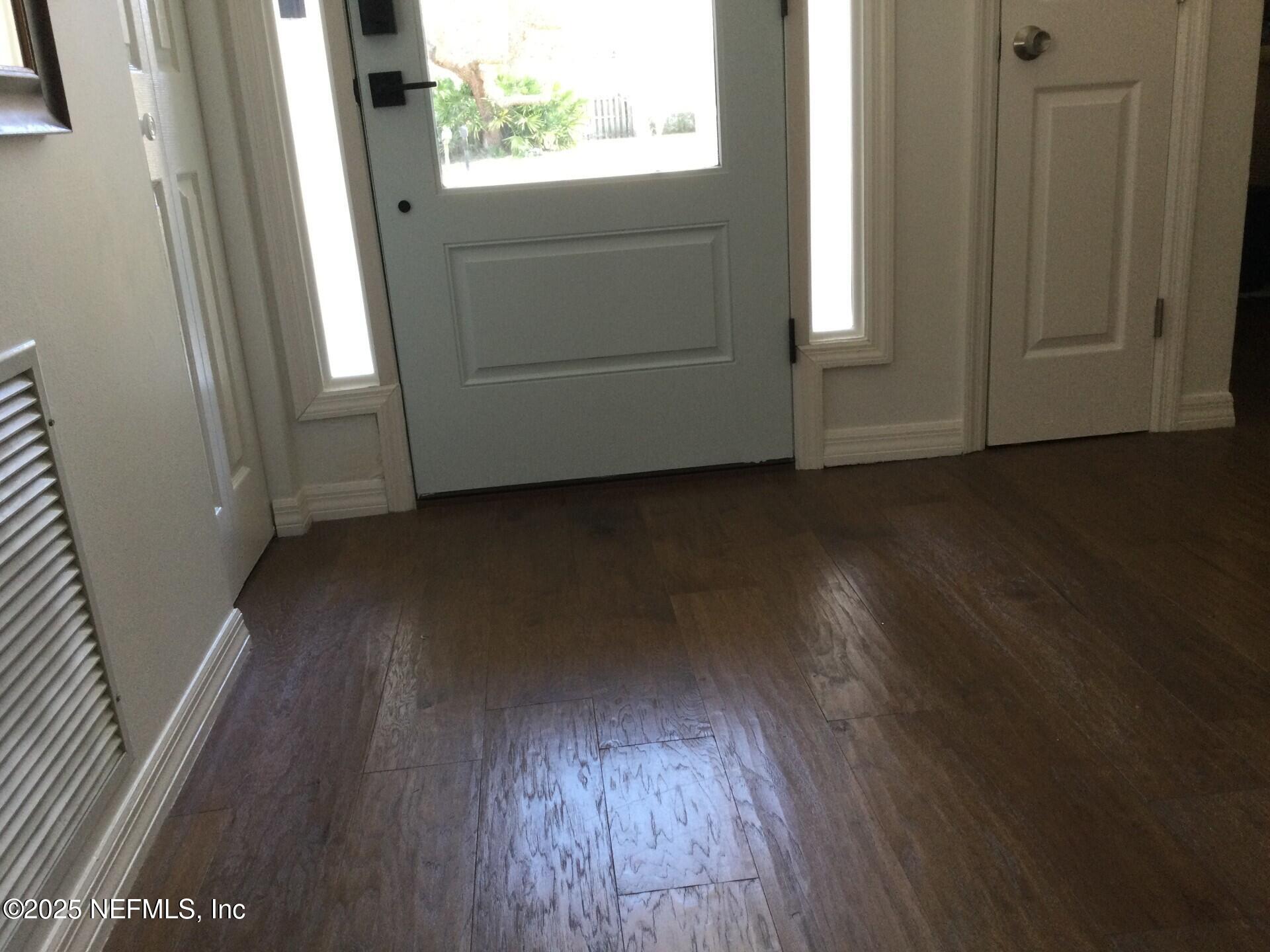 340 Shamrock Road St. Augustine, FL 32086 - Photo 10 of 21 an empty room with wooden floor and windows