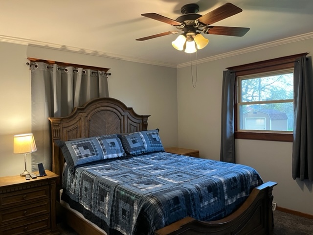 5833 South Skare Road Rochelle, IL 61068 - Photo 24 of 41 a bedroom with a bed and a chandelier