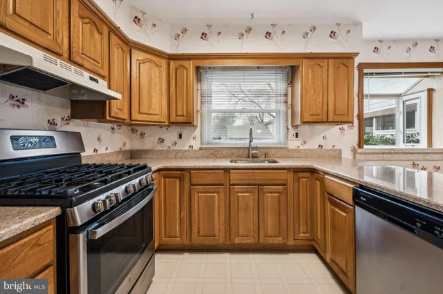 a kitchen with a sink stove top oven and cabinets