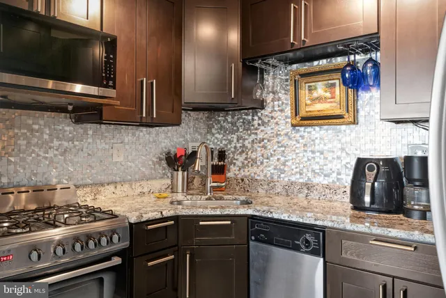 a kitchen with stainless steel appliances granite countertop a refrigerator and a sink
