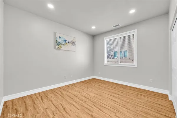 a view of empty room with wooden floor