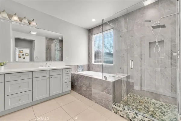 a spacious bathroom with a tub sink and mirror