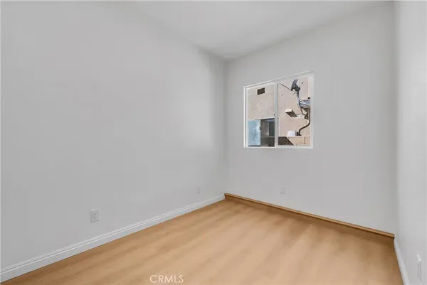 a view of a small space with wooden floor and a window