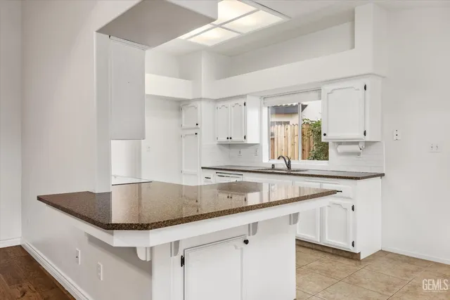 a kitchen with granite countertop a sink and cabinets