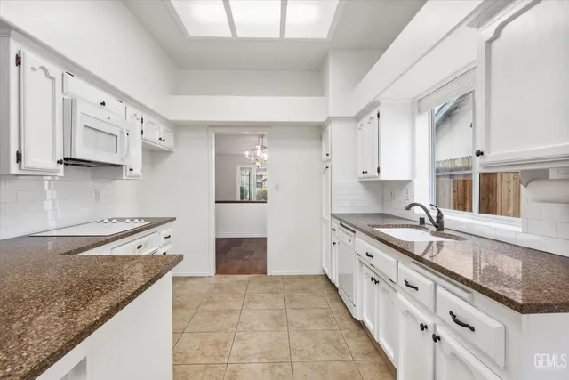 a kitchen with granite countertop a sink stove and cabinets