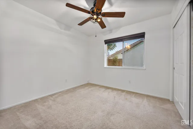 an empty room with a window and a fan