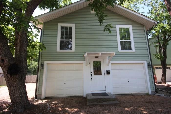 a front view of a house with a tree