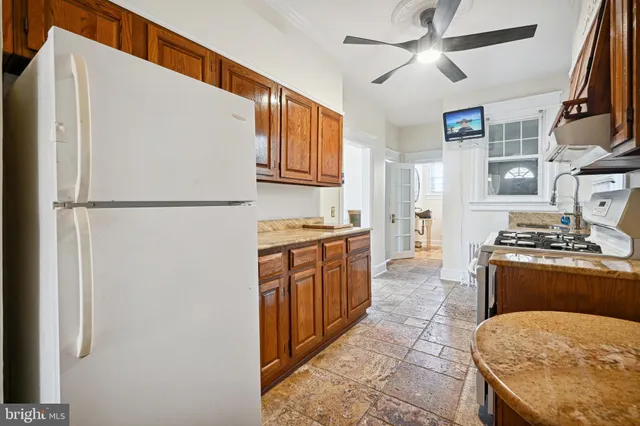 a kitchen with stainless steel appliances granite countertop a refrigerator a sink and white cabinets