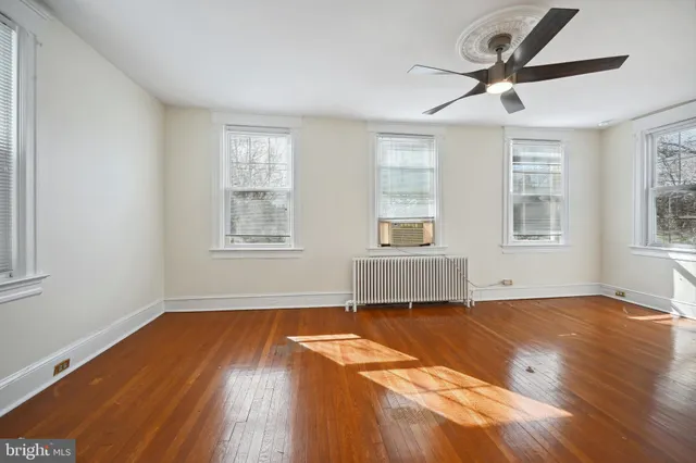 a view of empty room with wooden floor