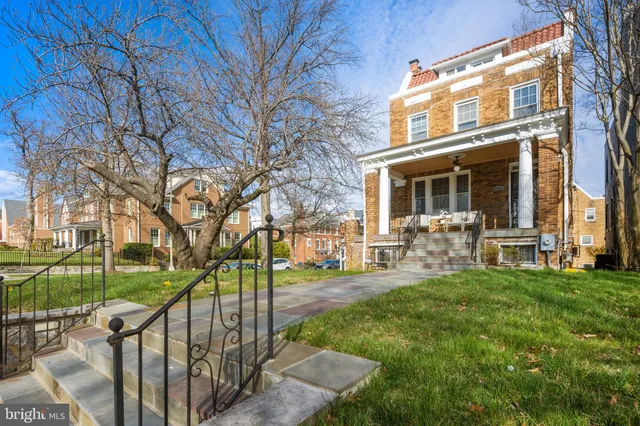 a view of front door with hallway and wooden floor