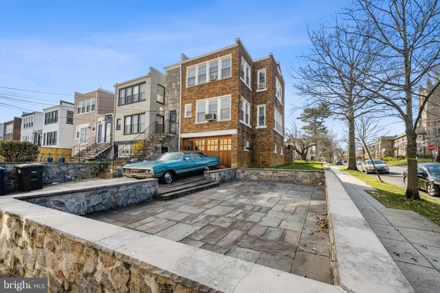 a backyard of a house with barbeque oven table and chairs