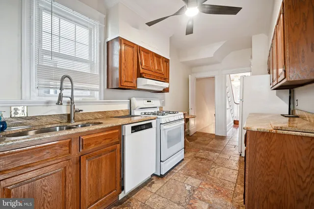 a kitchen with stainless steel appliances granite countertop a refrigerator a stove a sink and a refrigerator