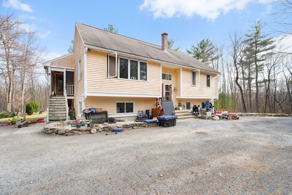 6 Plum Tree Lane Hubbardston, MA 01452 - Photo 2 of 31 a view of a patio with a table and chairs under an umbrella