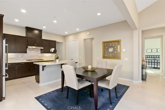a kitchen with a dining table chairs and refrigerator