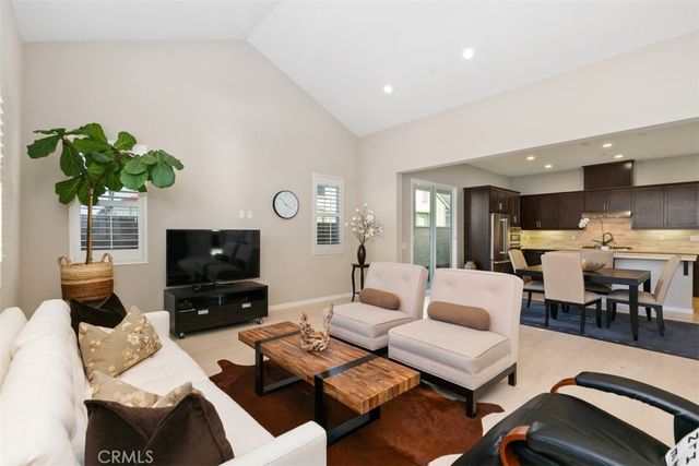 a living room with furniture a flat screen tv and a potted plant