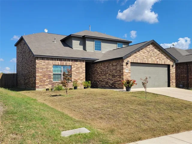 a front view of a house with a yard and garage