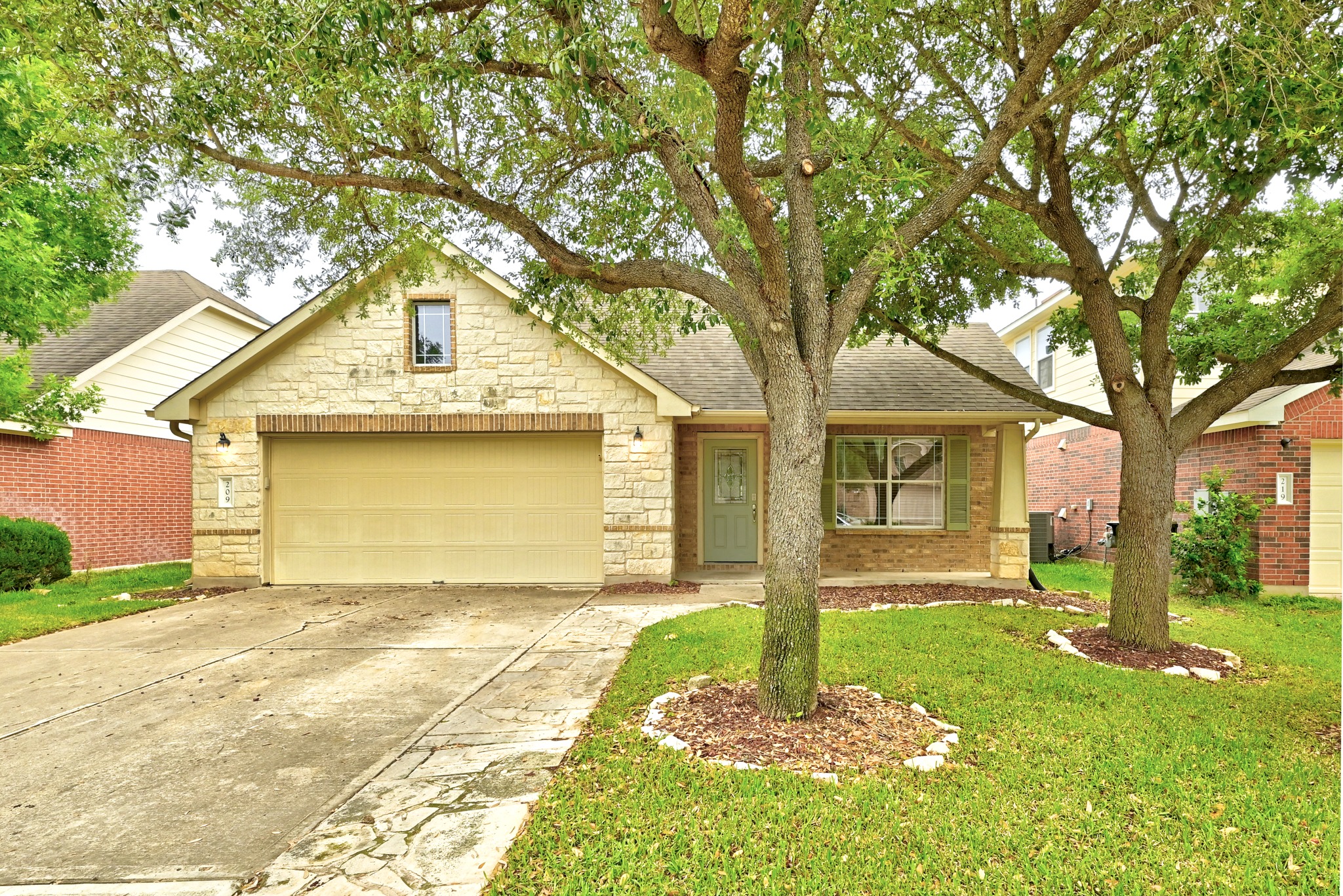 209 Calline Mayes Run Buda, TX 78610 - Photo 2 of 32 Single-story residence featuring a stone and brick façade with a gabled roofline