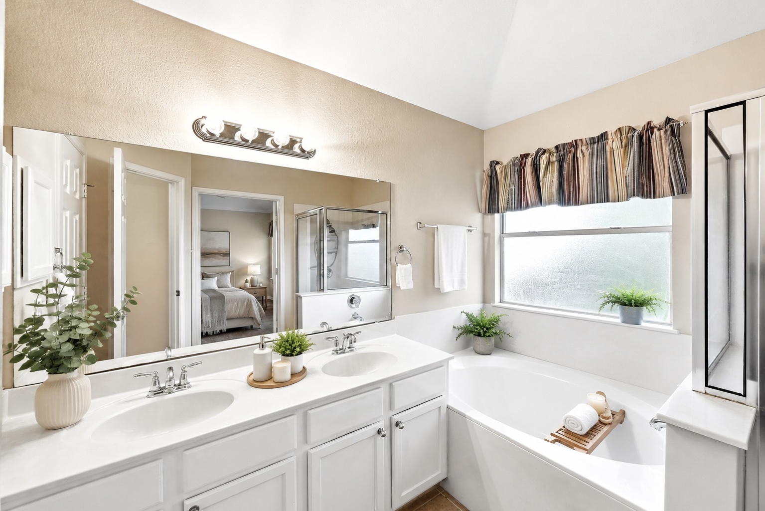 209 Calline Mayes Run Buda, TX 78610 - Photo 22 of 32 Virtually Staged - Double vanity with integrated sinks, a large wall-mounted mirror, and a soaking tub with an frosted window