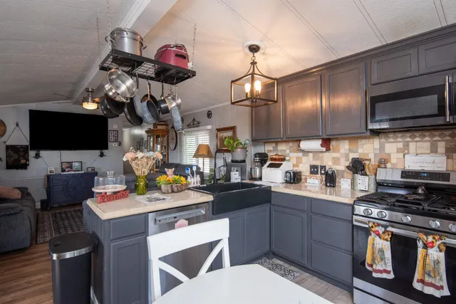 a kitchen with stainless steel appliances a sink stove and cabinets