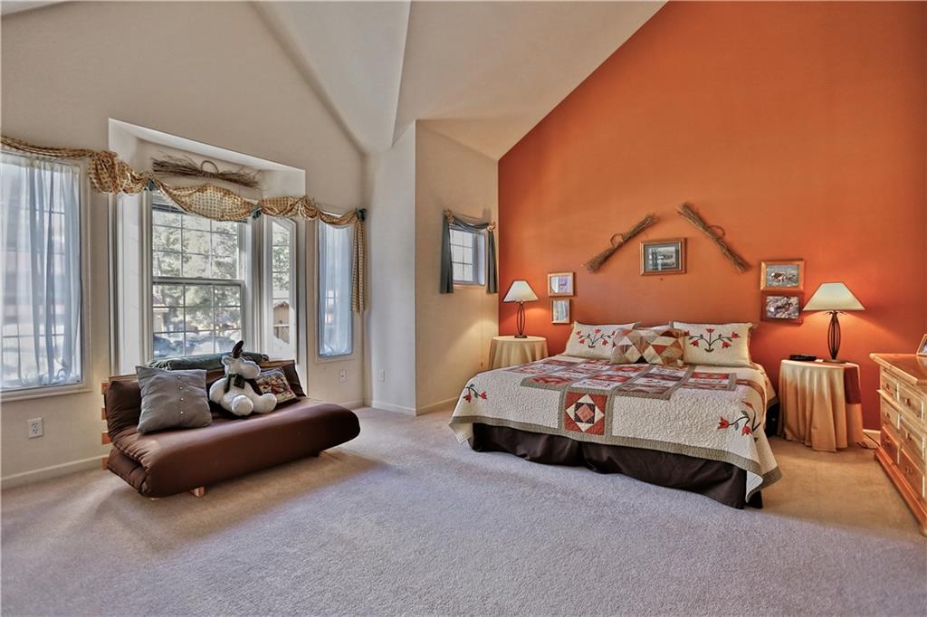 33 B Red Feather Road Breckenridge, CO 80424 - Photo 7 of 15 a spacious bedroom with a bed and a couch next to a window