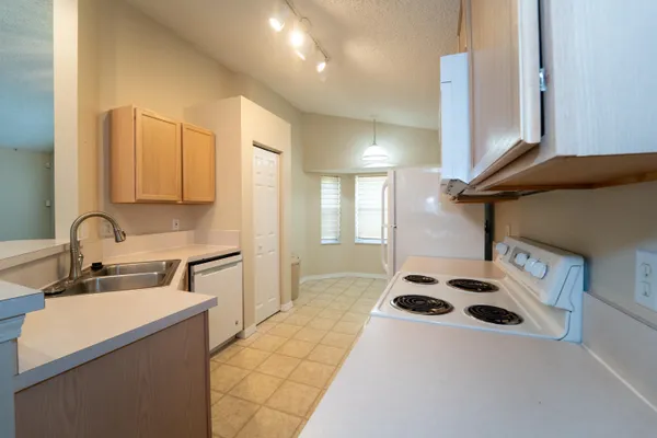 a kitchen with a sink a stove and a refrigerator