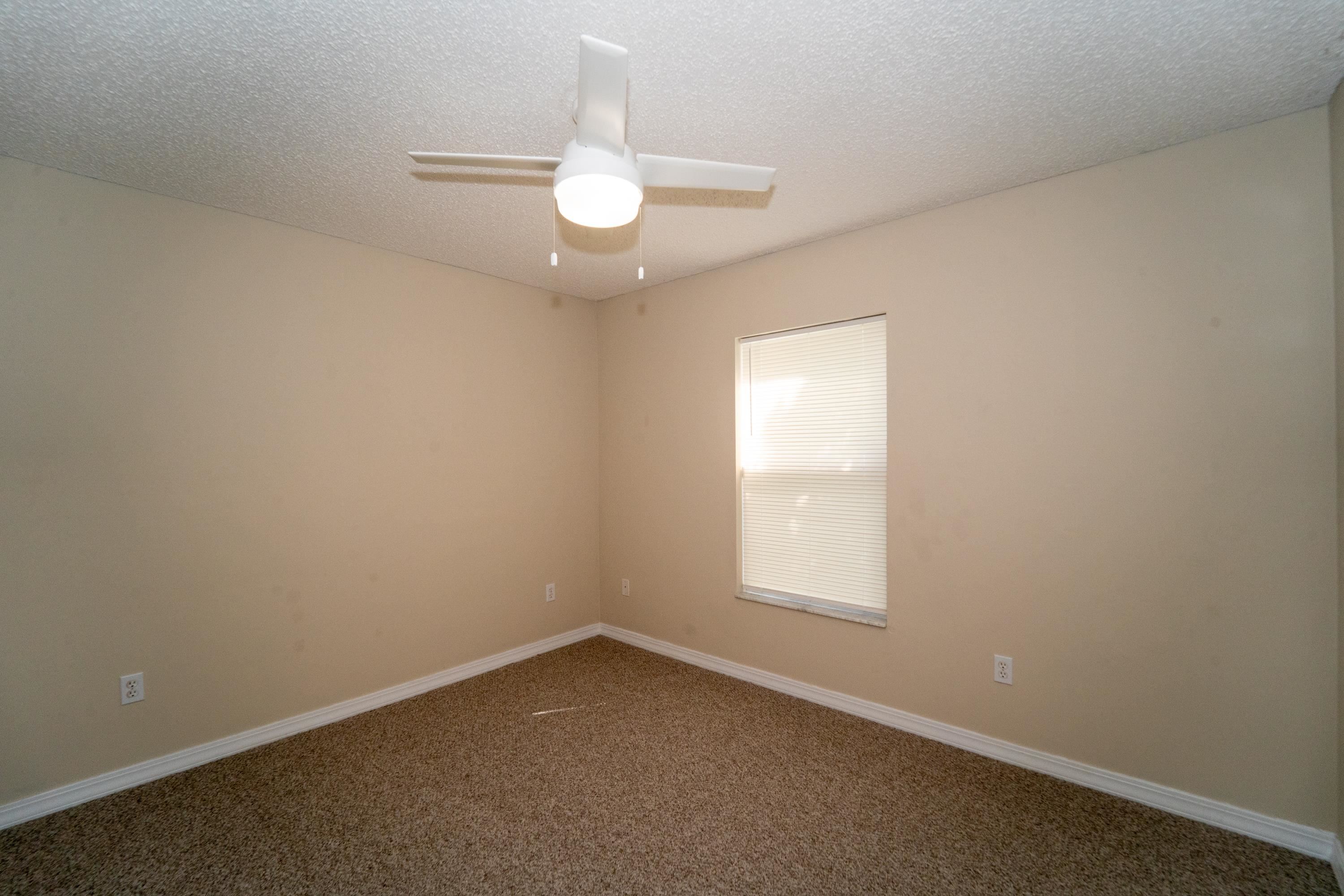 177 Marsh Island Circle St. Augustine, FL 32095 - Photo 22 of 33 an empty room with a chandelier fan and window