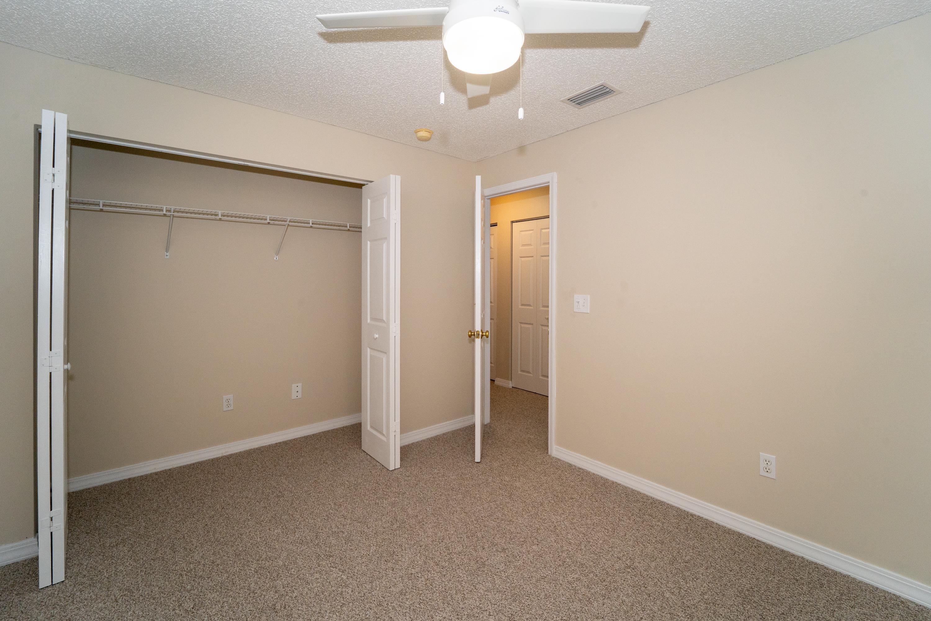 177 Marsh Island Circle St. Augustine, FL 32095 - Photo 24 of 33 an empty room with a chandelier fan and a bathroom