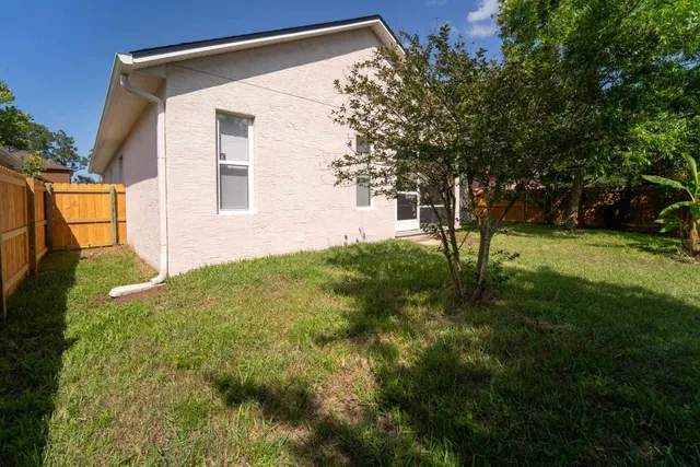 a house that is sitting in middle od the grass