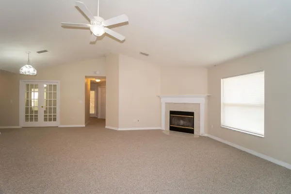 wooden floor fireplace and windows in an empty room