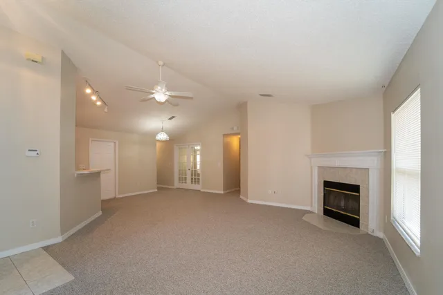 an empty room with a fireplace and fan