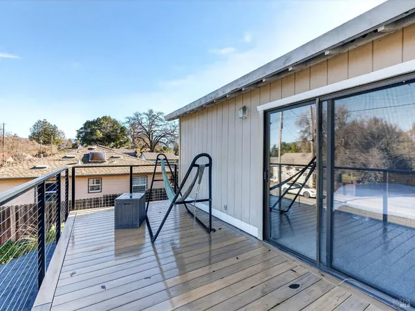 a balcony view with a dining table chairs and wooden floor