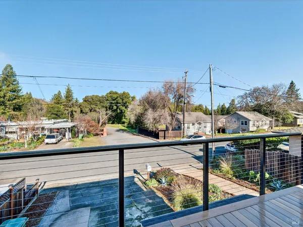 a view of a balcony with wooden floor and iron fence