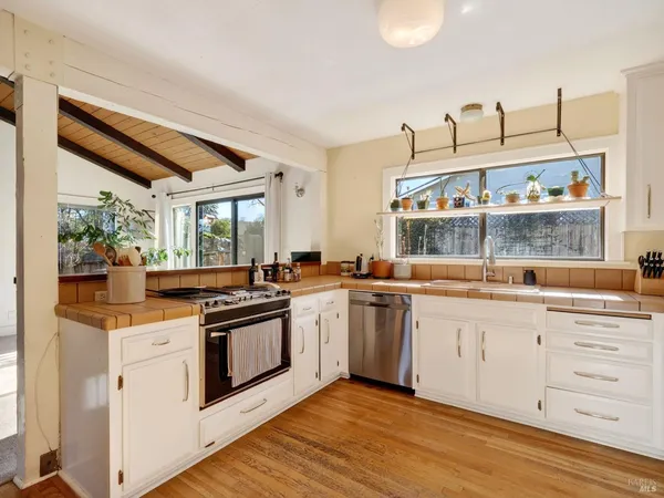 a kitchen with granite countertop white cabinets and white appliances