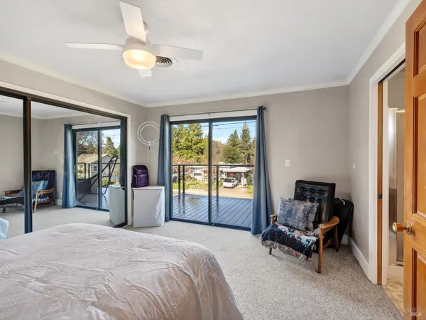 a bedroom with a bed and large windows