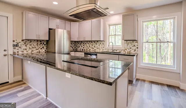 a kitchen with stainless steel appliances granite countertop a sink and a refrigerator