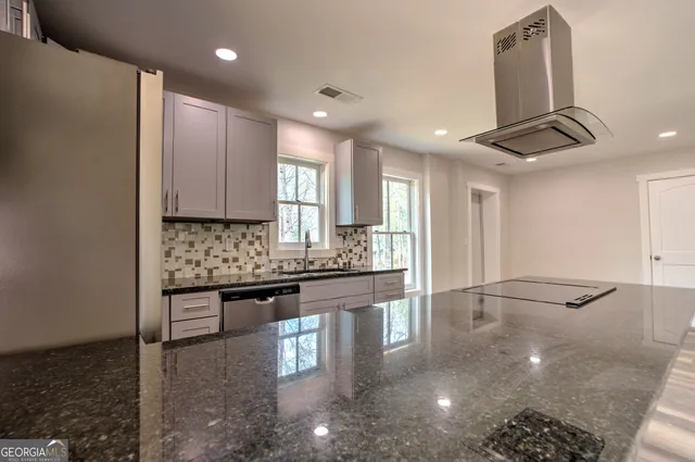 a kitchen with stainless steel appliances granite countertop a stove a sink and a refrigerator