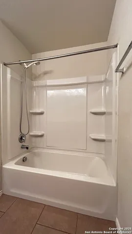 a bathroom with a shower and a bath tub