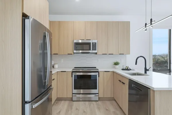 a kitchen with stainless steel appliances granite countertop a refrigerator and a stove top oven