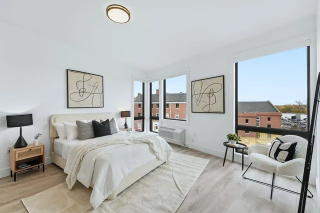 a bedroom with a bed a couch and painting on the wall