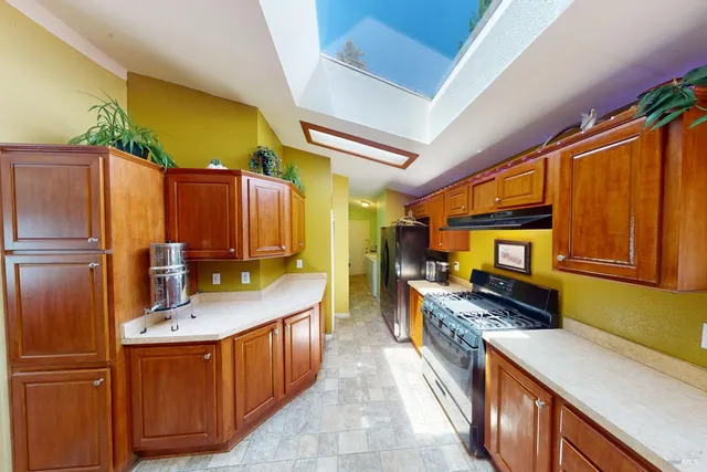 a kitchen with stainless steel appliances granite countertop a sink stove and refrigerator