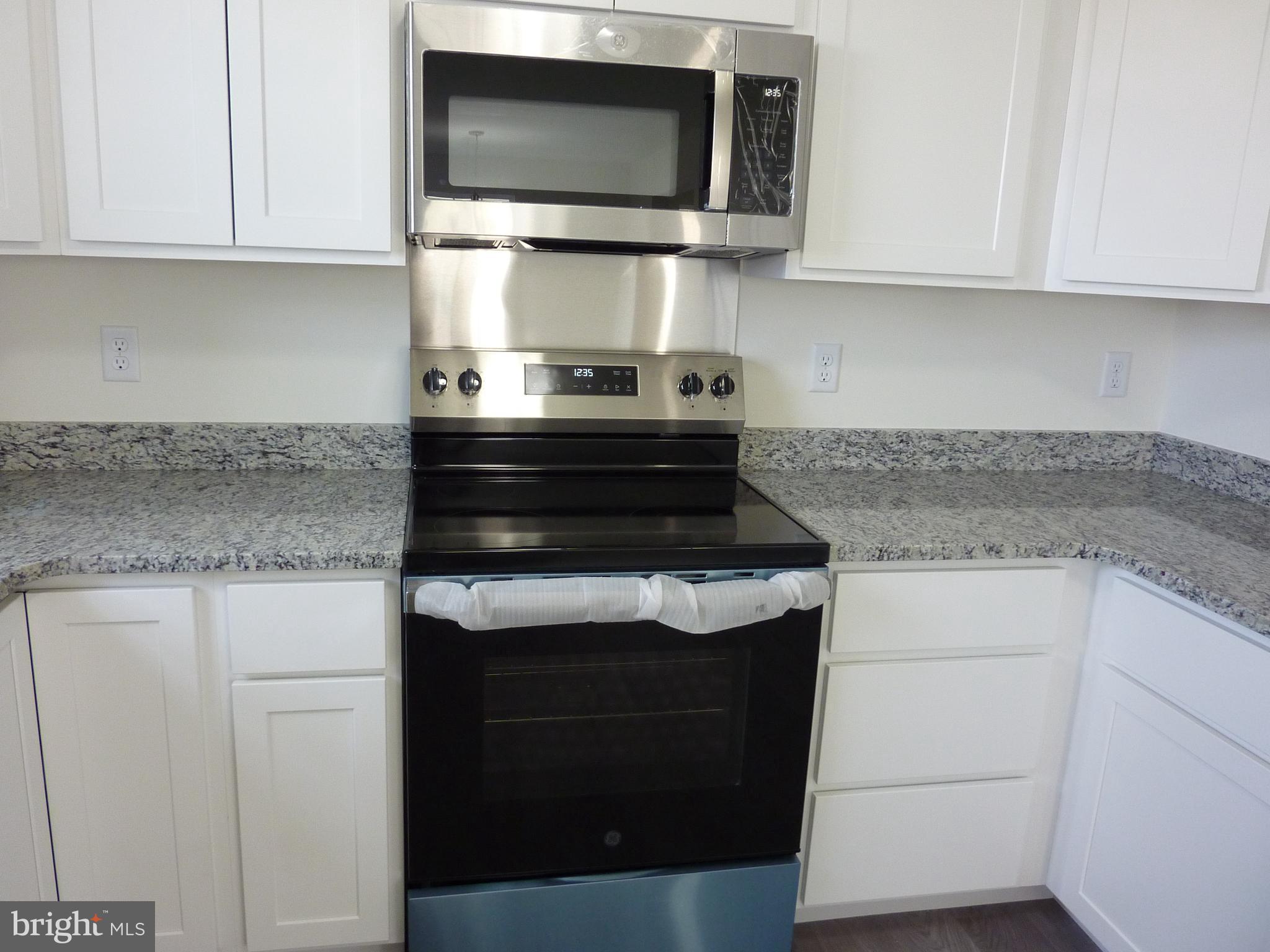 272 Doylestown Road Smyrna, DE 19977 - Photo 11 of 34 a kitchen with stainless steel appliances granite countertop a stove and a microwave