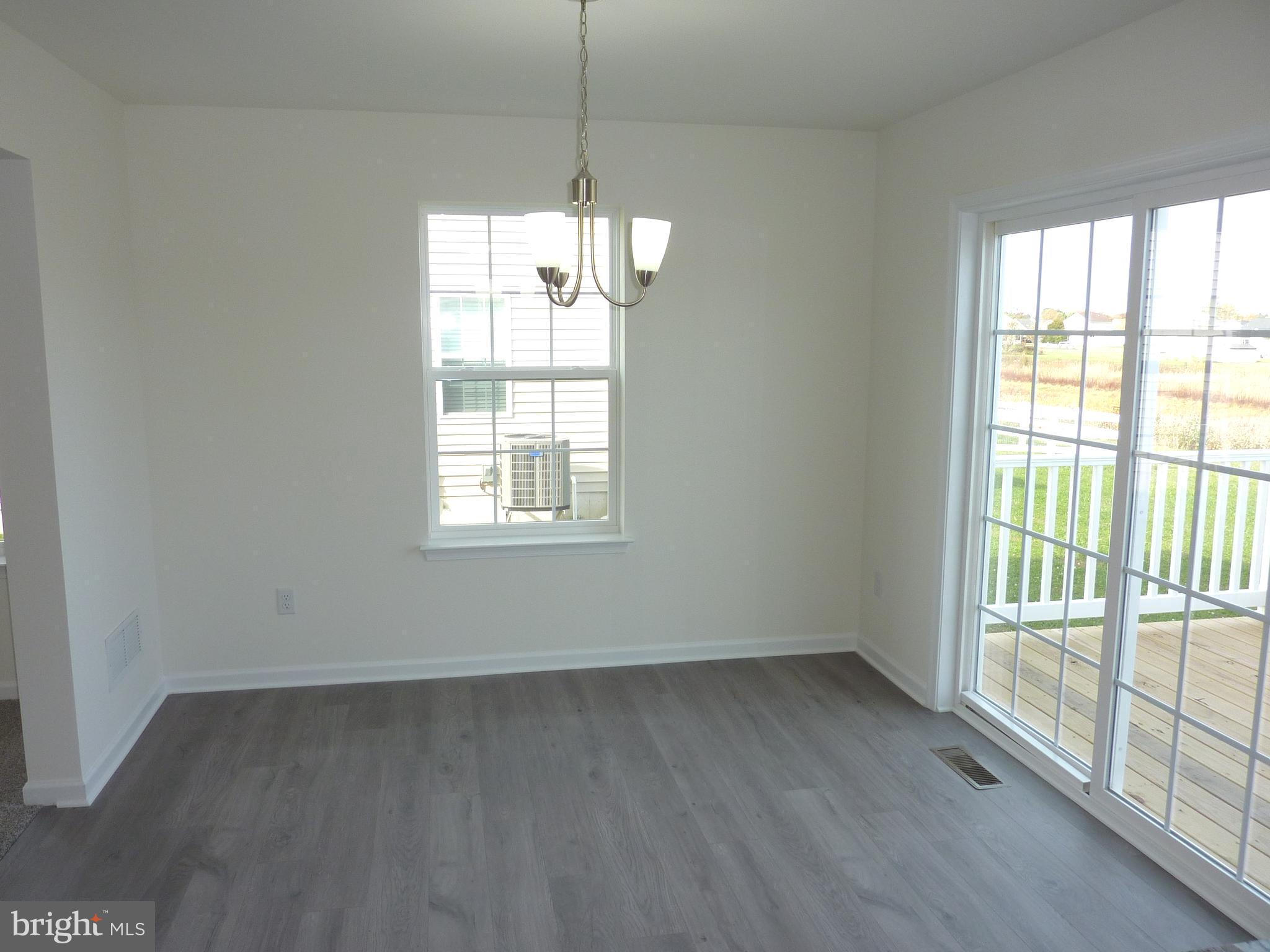 272 Doylestown Road Smyrna, DE 19977 - Photo 8 of 34 en empty room with wooden floor and windows